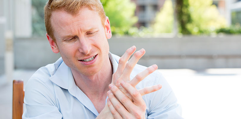 A man is gripping his wrist